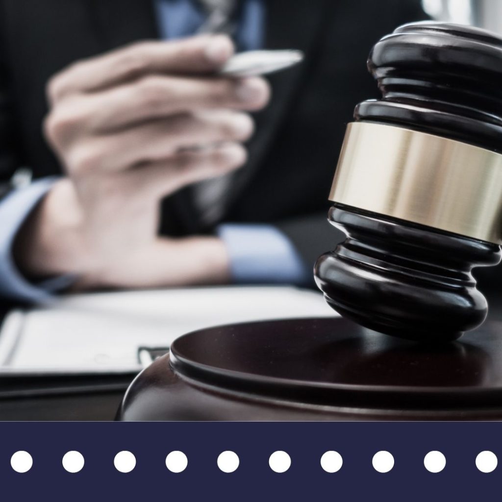 Judge gavel with a person in a suit behind them