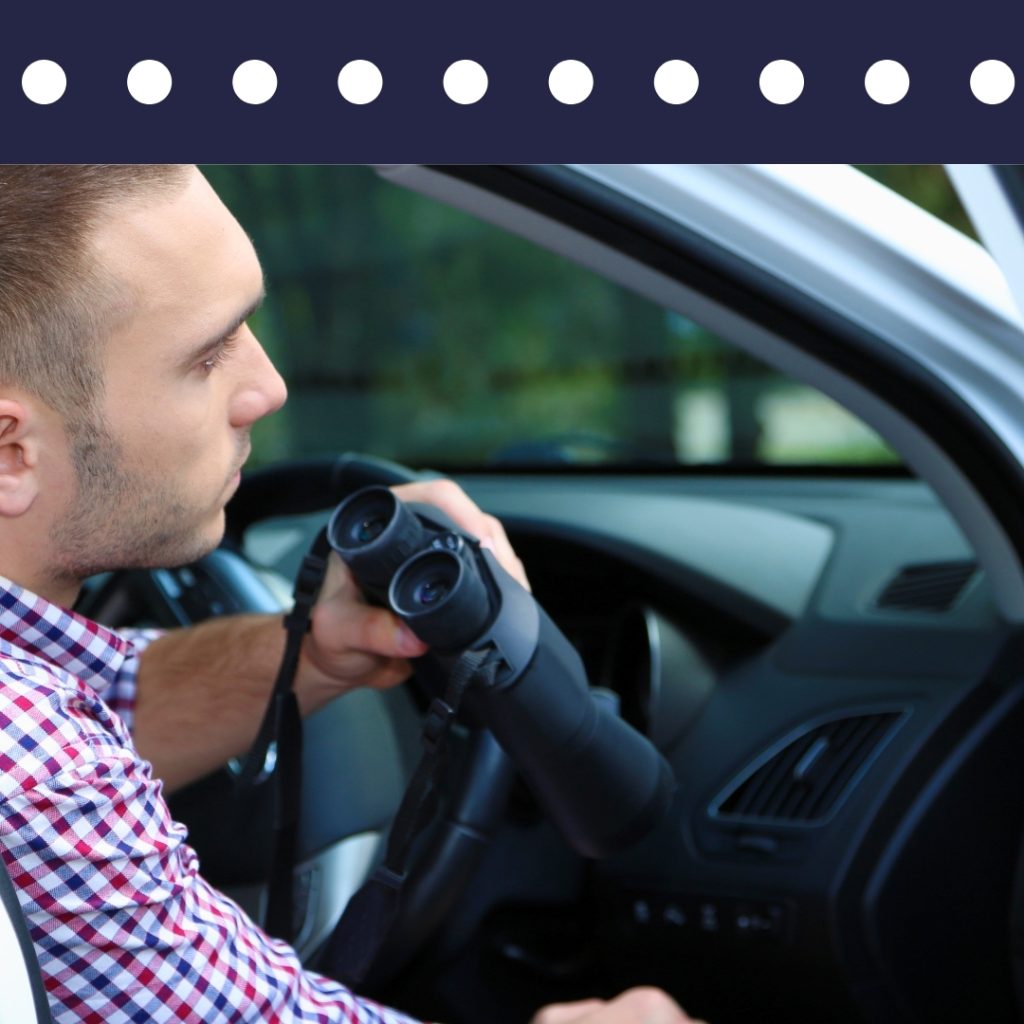 Private investigator conducting mobile surveillance with binoculars